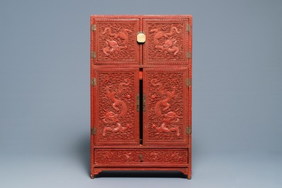 A Chinese cinnabar 'dragons and phoenixes' lacquer cabinet, 19th C.