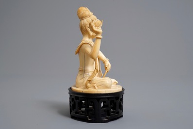 A Chinese carved ivory figure of Guanyin on wooden stand with original box, Republic, early 20th C.