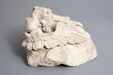 A carved stone wall fragment of a cherub's head with wing, 17/18th C.