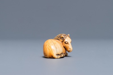 Een Japanse ivoren netsuke in de vorm van een liggend paard, Edo, 18/19e eeuw