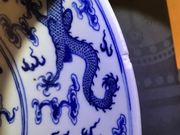 Un plat en porcelaine de Chine bleu et blanc &agrave; d&eacute;cor de dragons, marque de Qianlong, 19&egrave;me