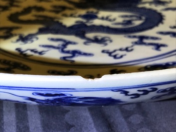 Un plat en porcelaine de Chine bleu et blanc &agrave; d&eacute;cor de dragons, marque de Qianlong, 19&egrave;me