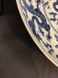 Un plat en porcelaine de Chine bleu et blanc &agrave; d&eacute;cor de dragons, marque de Qianlong, 19&egrave;me