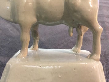 A pair of white Dutch Delft models of cows on bases, 18th C.