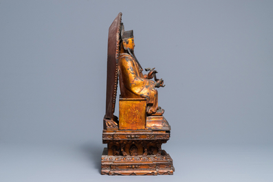 A large Chinese gilt-laquered and inlaid bronze figure of Zhenwu on gilt wooden base, Ming