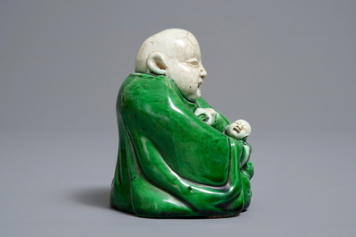 Een Chinese verte biscuit figuur van Boeddha met een kind, Kangxi