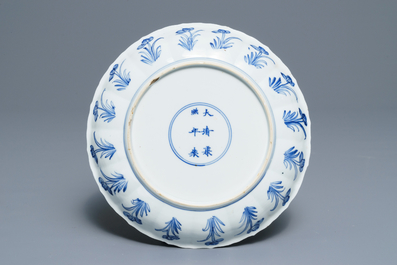 A Chinese blue and white moulded plate with an amorous couple, Kangxi mark and of the period