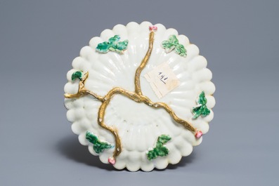 A Chinese famille rose lotus-shaped relief-decorated cup and saucer, Yongzheng