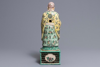 A large Chinese verte biscuit figure of an immortal on reticulated stand, Kangxi