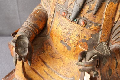 A large Chinese gilt-laquered and inlaid bronze figure of Zhenwu on gilt wooden base, Ming