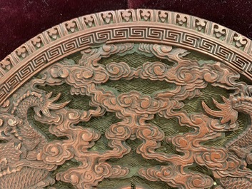 A round Chinese cinnabar lacquer plaque with two dragons, 18th C.