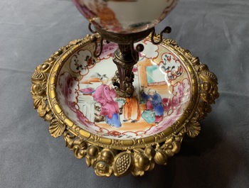 Une tasse et soucoupe en porcelaine de Chine famille rose &agrave; monture en m&eacute;tal dor&eacute;, Qianlong et 19&egrave;me