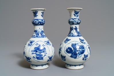 Une paire de vases de forme bouteille en porcelaine de Chine bleu et blanc, Kangxi