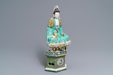 A Chinese verte biscuit group of Guanyin with child on a lotus throne, Kangxi