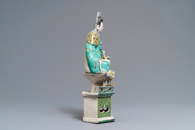 A Chinese verte biscuit group of Guanyin with child on a lotus throne, Kangxi