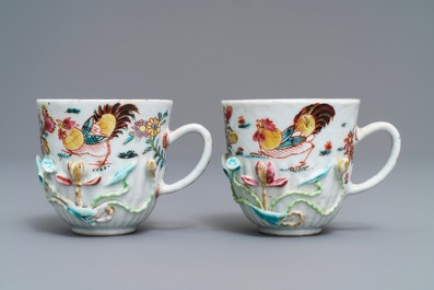 A pair of Chinese famille rose 'rooster' cups and saucers with applied floral designs, Yongzheng