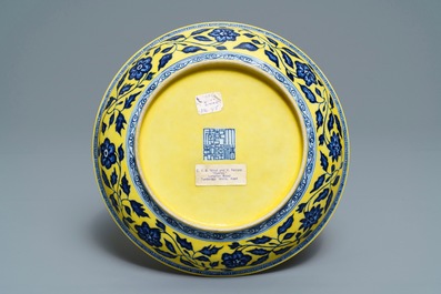 Une assiette en porcelaine de Chine &agrave; d&eacute;cor d'un bouquet en bleu et blanc sur fond jaune, marque de Qianlong, 19/20&egrave;me