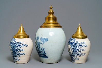 Three Dutch Delft blue and white tobacco jars with brass covers, 18th C.