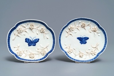 A pair of Chinese blue and white 'soft paste' relief-decorated cups and saucers, Qianlong