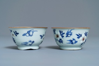 A pair of Chinese blue, white and underglaze red cups and saucers, Kangxi