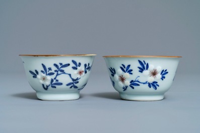 A pair of Chinese blue, white and underglaze red cups and saucers, Kangxi