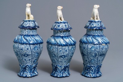 Three Dutch Delft blue and white dog-topped vases and covers, 18th C.