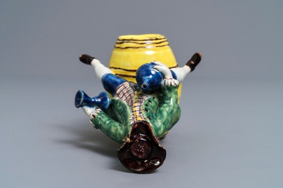 A polychrome Dutch Delft figure of a man on a barrel, 18th C.