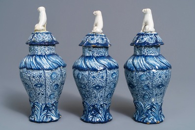 Three Dutch Delft blue and white dog-topped vases and covers, 18th C.