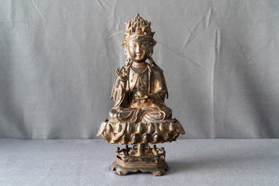 Een Chinese gelakt en verguld bronzen figuur van Guanyin op een lotustroon, Ming