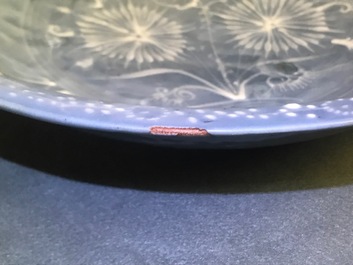 Un plat en porcelaine de Chine dite 'de Swatow' &agrave; d&eacute;cor appliqu&eacute; sur fond bleu, Ming