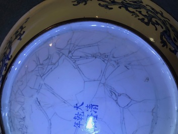 Une assiette en &eacute;maux de Canton &agrave; d&eacute;cor de figures dans un jardin, marque et &eacute;poque de Qianlong