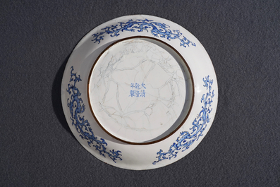 Une assiette en &eacute;maux de Canton &agrave; d&eacute;cor de figures dans un jardin, marque et &eacute;poque de Qianlong