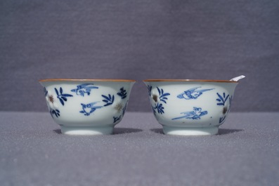 A pair of Chinese blue, white and underglaze red cups and saucers, Kangxi