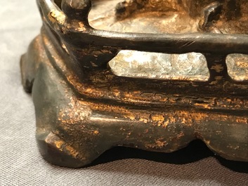 Een Chinese gelakt en verguld bronzen figuur van Guanyin op een lotustroon, Ming