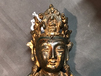 Een Chinese gelakt en verguld bronzen figuur van Guanyin op een lotustroon, Ming