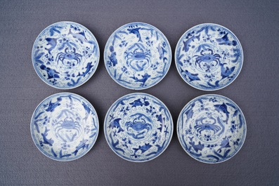 Six Chinese celadon and blue and white 'crabs and fish' cups and saucers, Kangxi