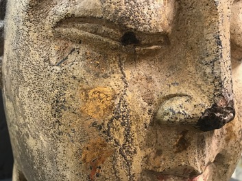 A Chinese carved stone head of Buddha with traces of gilding and polychromy, Ming