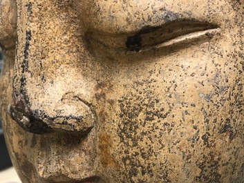 Une t&ecirc;te de Bouddha en pierre sculpt&eacute;e, traces de dorure et polychromie, Chine, Ming