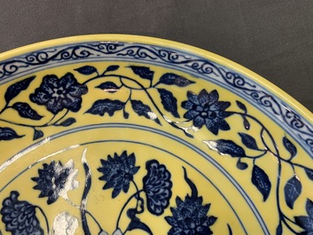 Une assiette en porcelaine de Chine &agrave; d&eacute;cor d'un bouquet en bleu et blanc sur fond jaune, marque de Qianlong, 19/20&egrave;me