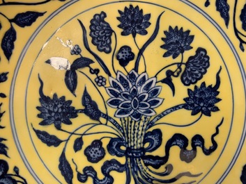 Une assiette en porcelaine de Chine &agrave; d&eacute;cor d'un bouquet en bleu et blanc sur fond jaune, marque de Qianlong, 19/20&egrave;me