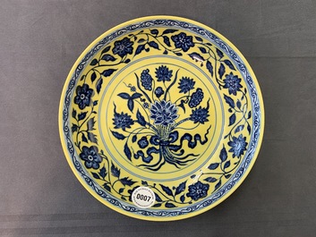 Une assiette en porcelaine de Chine &agrave; d&eacute;cor d'un bouquet en bleu et blanc sur fond jaune, marque de Qianlong, 19/20&egrave;me