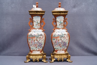 Une paire de vases en porcelaine de Chine famille rose &agrave; d&eacute;cor mandarin aux montures en bronze dor&eacute;, Qianlong