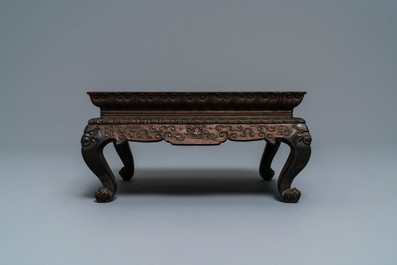 A Chinese carved wooden stand with famille rose plaque, 19th C.