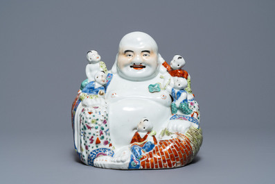 A Chinese famille rose figure of Buddha and a famille rose boy on qilin, 19th C.