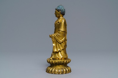 Een Chinese verguld bronzen figuur van een staande Boeddha met inscriptie, Qianlong