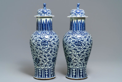 A pair of Chinese blue and white vases and covers with floral sprigs, 19th C.