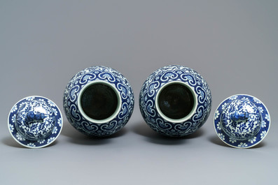 A pair of Chinese blue and white vases and covers with floral sprigs, 19th C.