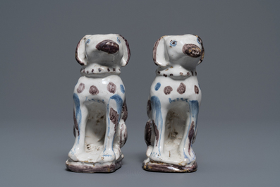 A pair of blue, white and manganese Brussels faience models of dogs, 18th C.