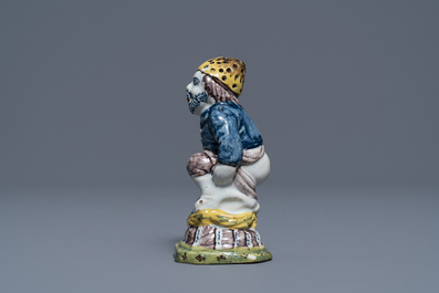 A rare polychrome Dutch Delft caster in the shape of a pooping man, 18th C.