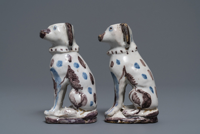 A pair of blue, white and manganese Brussels faience models of dogs, 18th C.